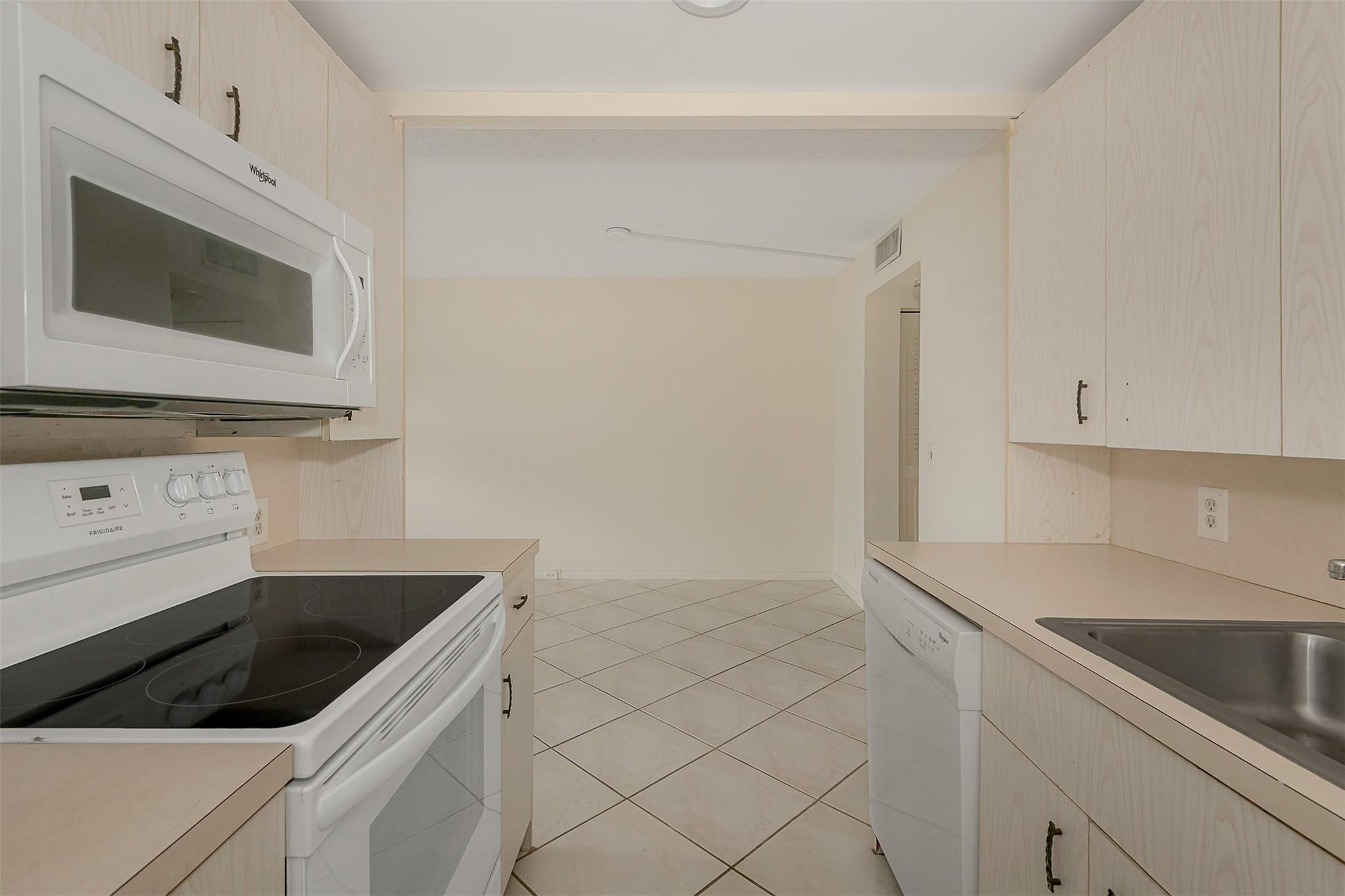 2009 Cornwall Drive, Unit 2009 Boca Raton, FL 33434 - Photo 9 of 23 a kitchen with granite countertop white cabinets and white stainless steel appliances