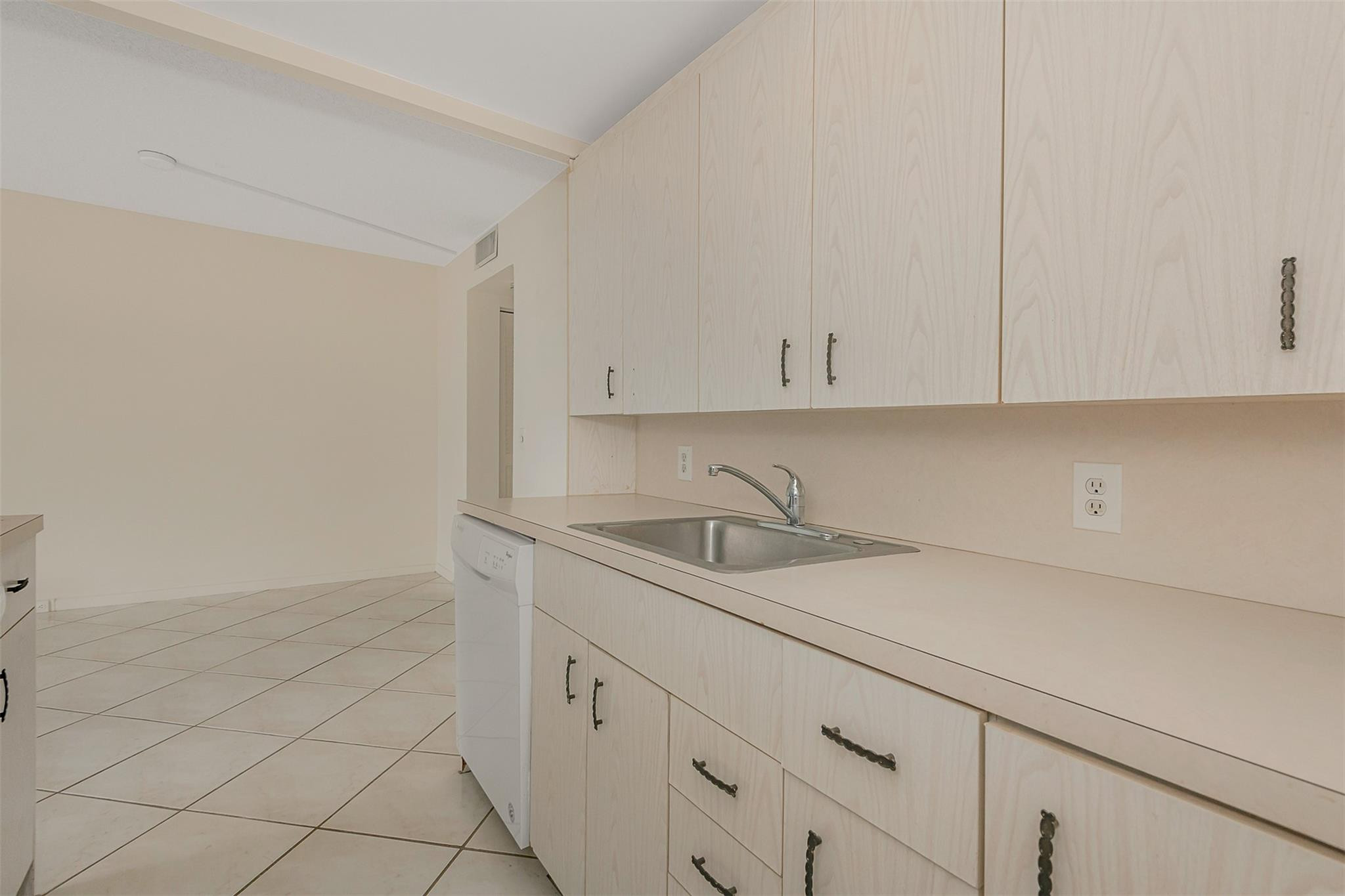 2009 Cornwall Drive, Unit 2009 Boca Raton, FL 33434 - Photo 10 of 23 a kitchen with white cabinets and a sink
