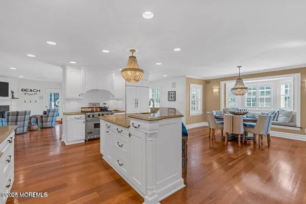 a large kitchen with stainless steel appliances granite countertop a sink and a stove next to a large window