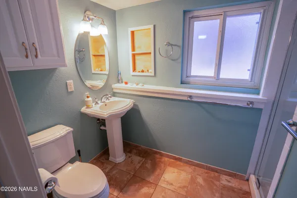 a bathroom with a toilet sink and mirror