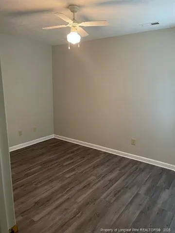 a view of a room with wooden floor and a ceiling fan