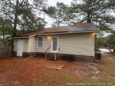 a view of house with backyard and a tree
