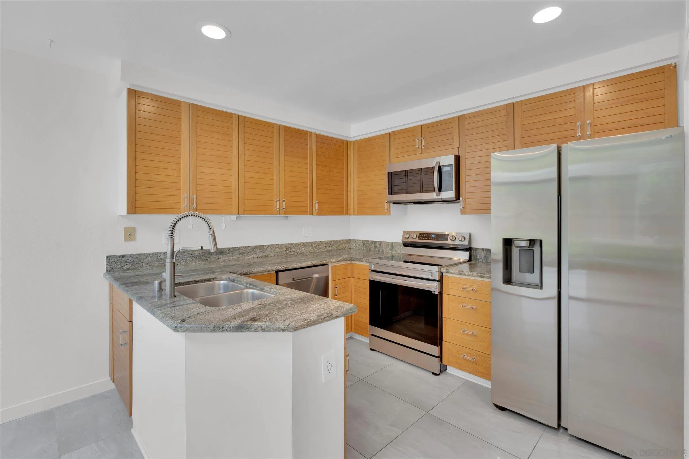 6426 Caminito Listo San Diego, CA 92111 - Photo 13 of 48 a kitchen with granite countertop a refrigerator and a sink