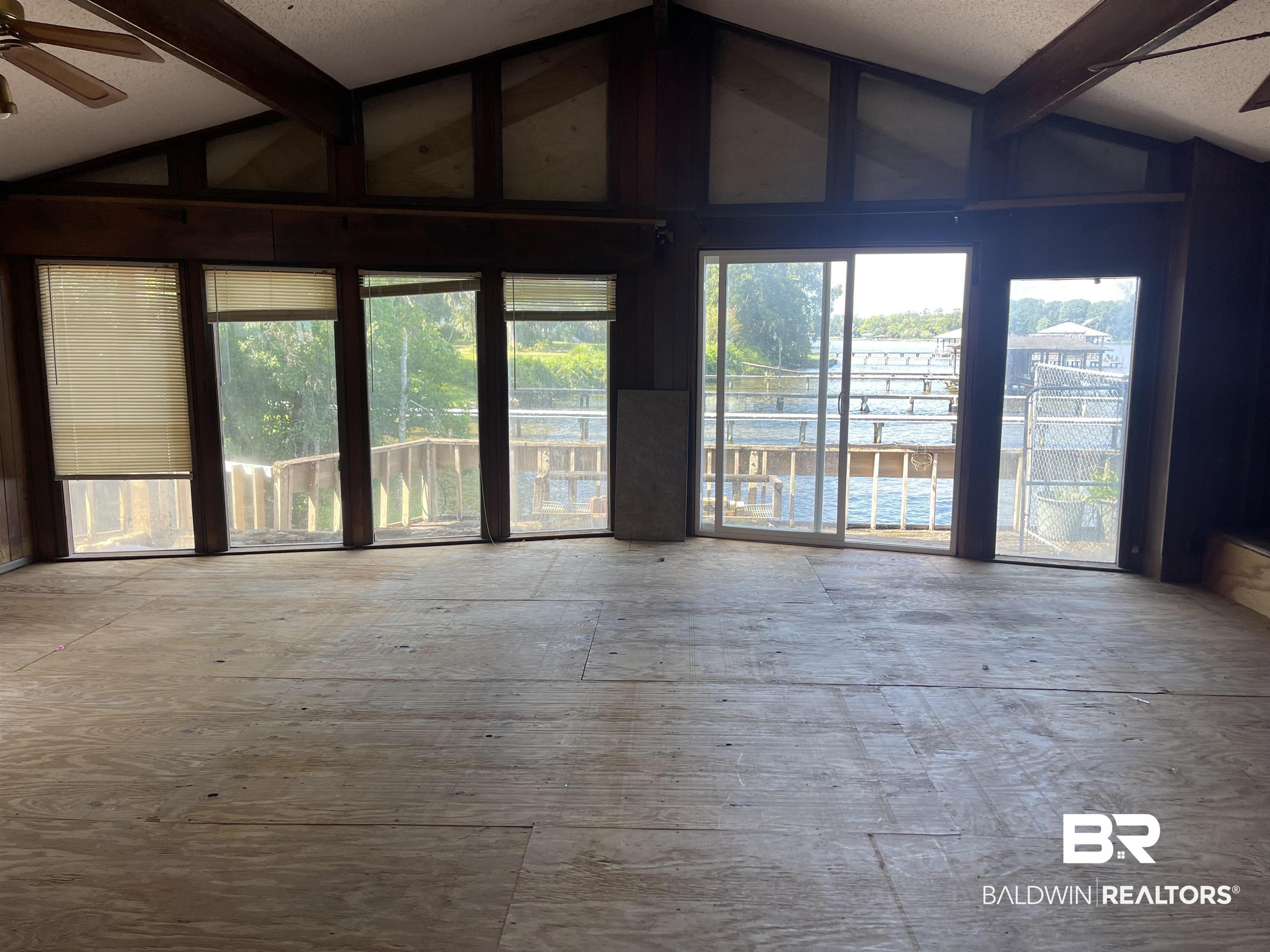 3074 Riverside Drive West Mobile, AL 36605 - Photo 7 of 15 Unfurnished room with beam ceiling, high vaulted ceiling, and ceiling fan