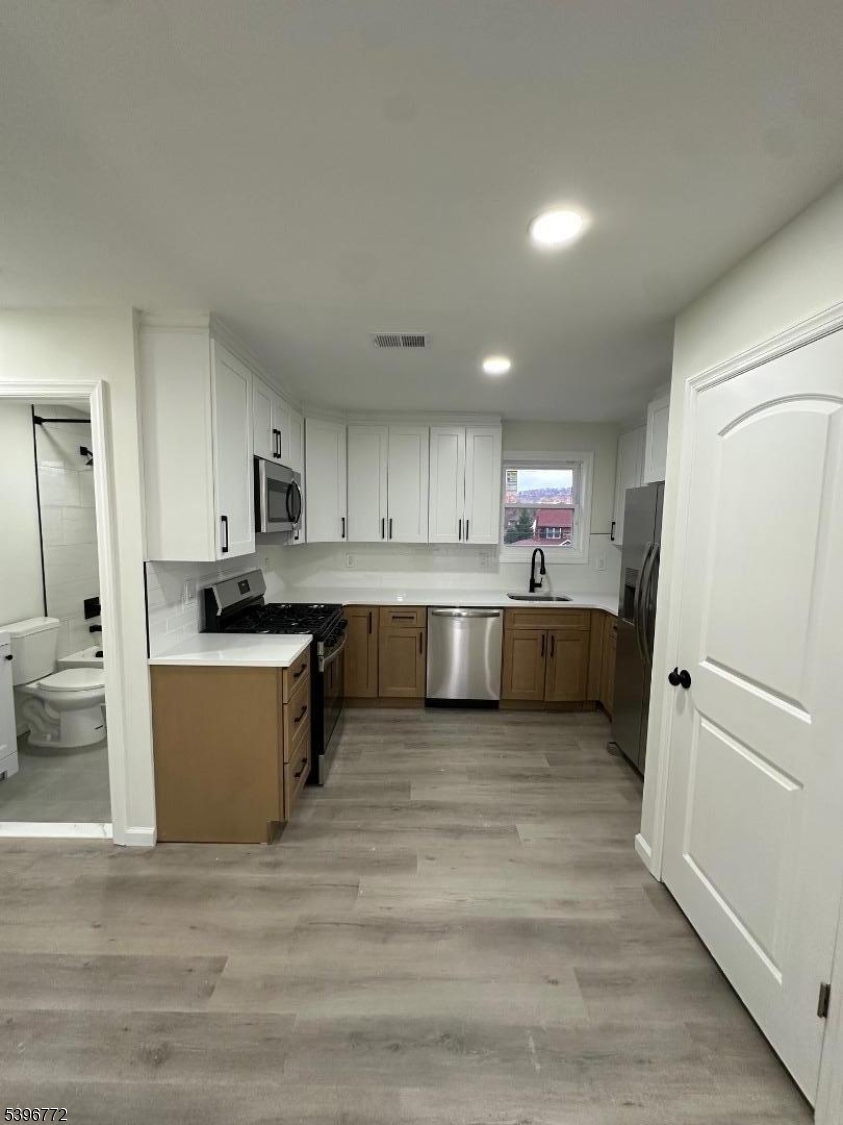 112 Fairview Avenue, Unit 2 Middlesex, NJ 08846 - Photo 11 of 29 a large kitchen with a refrigerator a stove top oven a counter space and cabinets