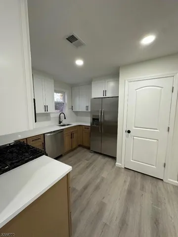 a kitchen with a refrigerator a sink and wooden cabinets