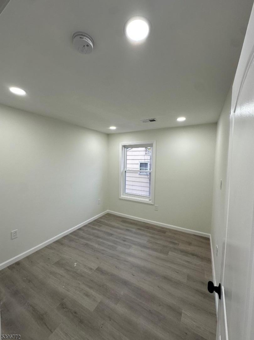 112 Fairview Avenue, Unit 2 Middlesex, NJ 08846 - Photo 6 of 29 an empty room with wooden floor and windows