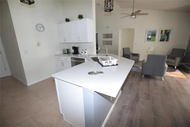 a view of kitchen with sink and refrigerator