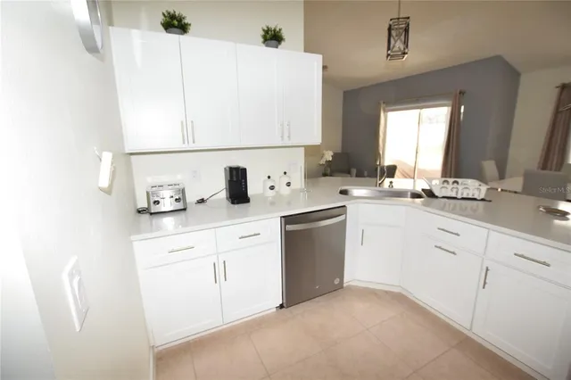 a kitchen with cabinets appliances a sink and a window