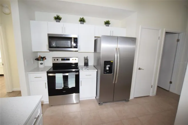 a kitchen with stainless steel appliances a refrigerator and a microwave