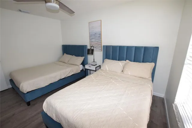 a bed sitting in a bedroom next to a window with wooden floor