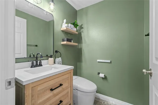 a bathroom with a sink vanity mirror and toilet