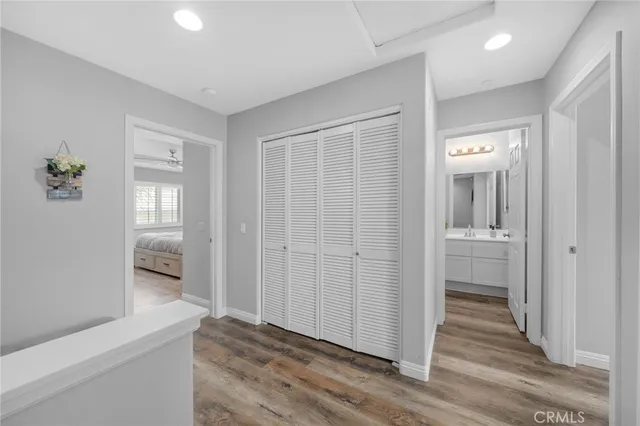 a view of a hallway with wooden floor and closet area