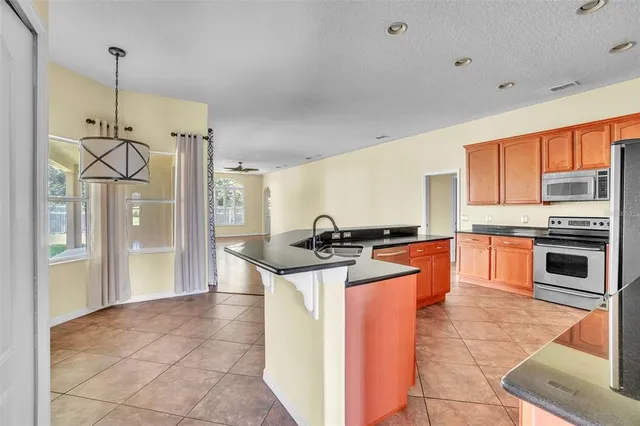 a kitchen with stainless steel appliances granite countertop a stove a sink and a refrigerator