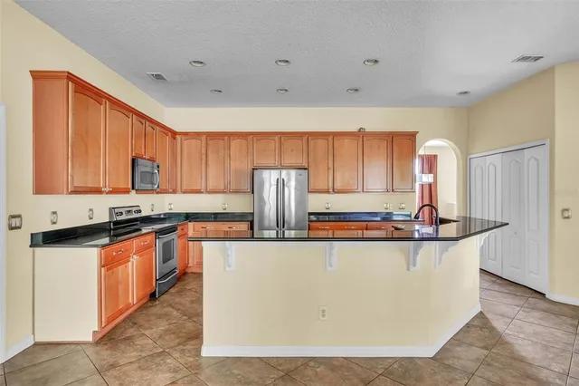 a kitchen with stainless steel appliances granite countertop a stove a sink and a refrigerator