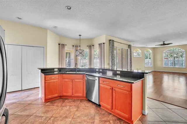 a large kitchen with granite countertop a sink and cabinets