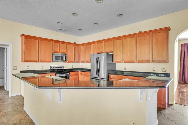 a kitchen with stainless steel appliances granite countertop a sink a stove and refrigerator