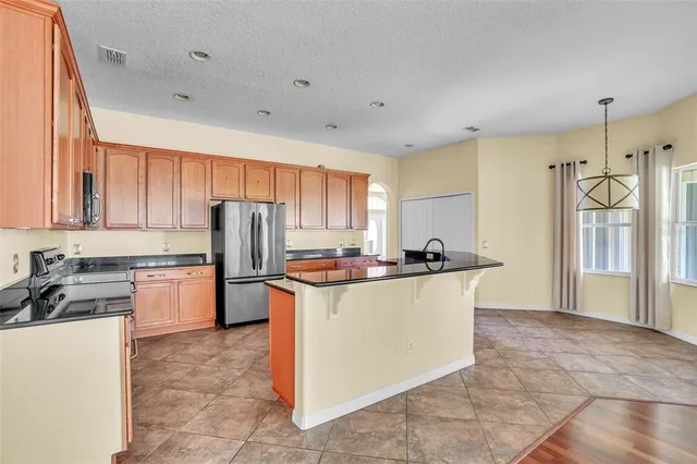 a kitchen with stainless steel appliances granite countertop a stove top oven a refrigerator a sink and dishwasher