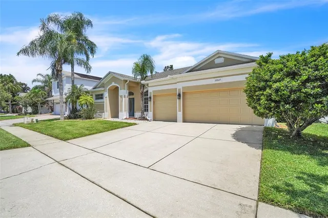 a front view of a house with a garden and trees