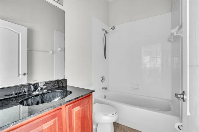 a bathroom with a bathtub sink vanity mirror and toilet