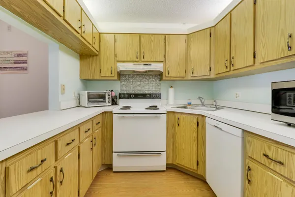 a kitchen with cabinets appliances a sink and a window