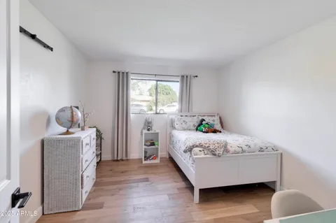 a bedroom with a bed and a lamp on dresser