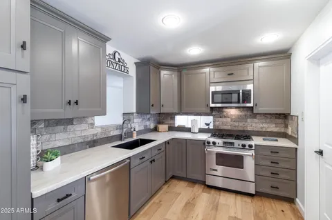 a kitchen with stainless steel appliances granite countertop a sink stove and cabinets