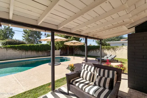 a view of a house with a yard and large tree