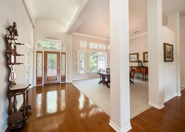 wooden floor in a livingroom with a dining table and a chandelier