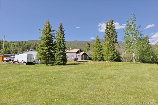 a front view of a house with a garden and mountain view