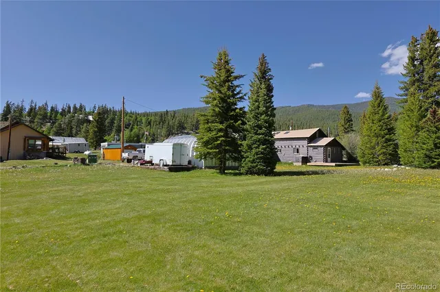 a front view of a house with a garden and trees