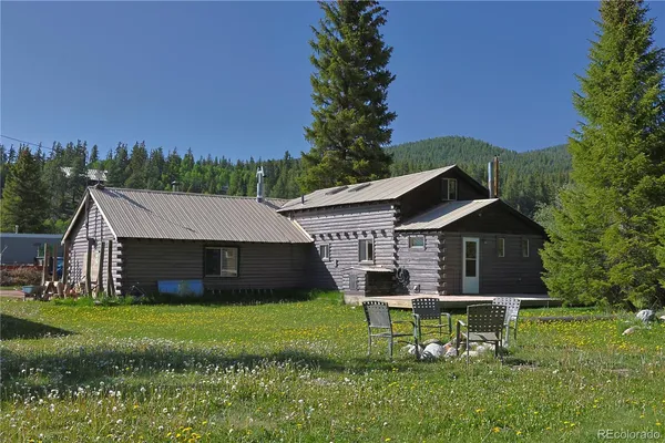 a front view of a house with a garden and trees