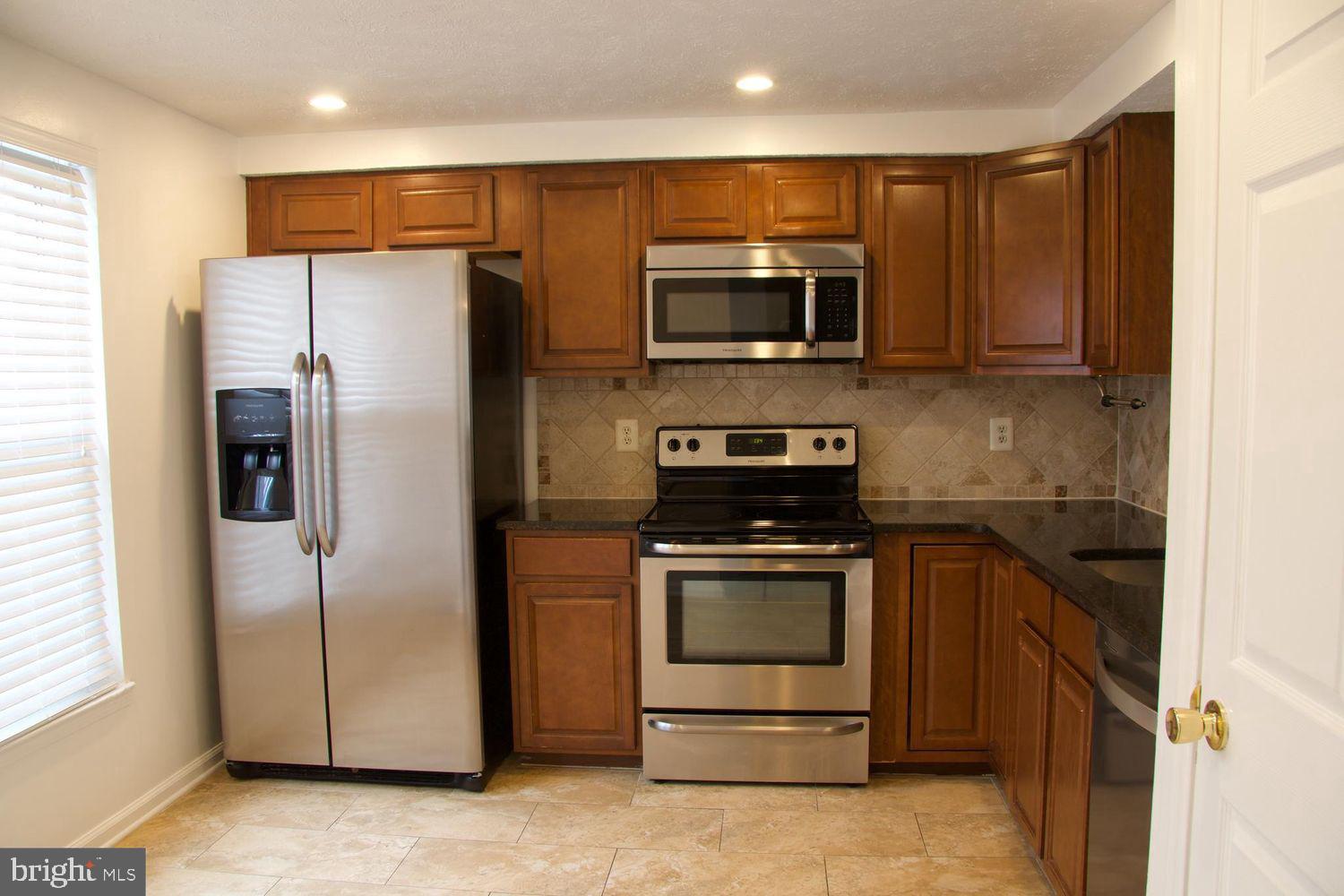 1831 Tilletson Place Woodbridge, VA 22191 - Photo 8 of 18 a kitchen with stainless steel appliances granite countertop a refrigerator stove and microwave