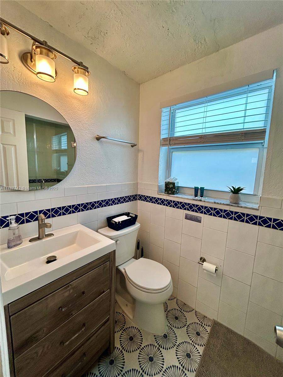 316 Walnut Street, Unit 1 Hollywood, FL 33019 - Photo 6 of 15 a bathroom with a sink a toilet and mirror