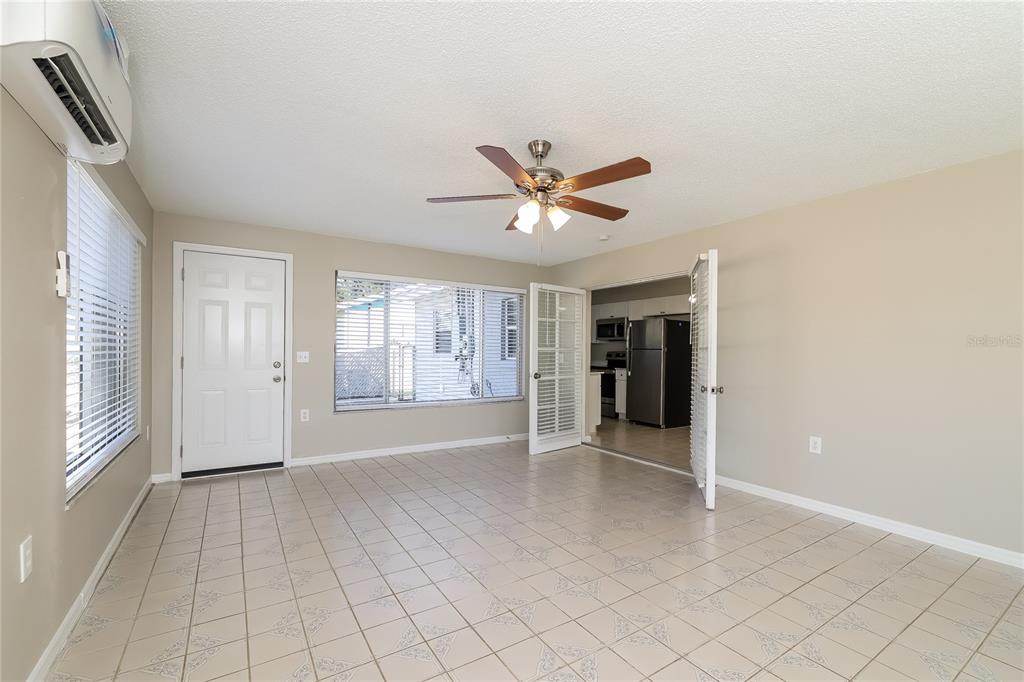 4243 Cynthia Street Orlando, FL 32811 - Photo 11 of 16 an empty room with windows and a ceiling fan