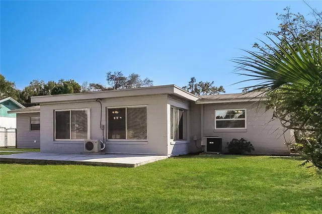 a view of a house with a yard and potted plants