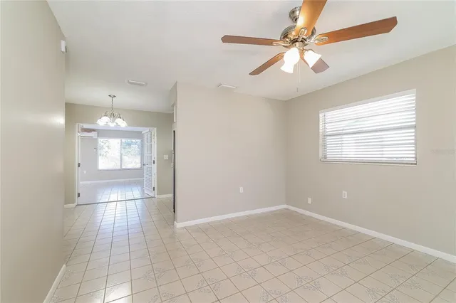 a view of an empty room with a chandelier fan