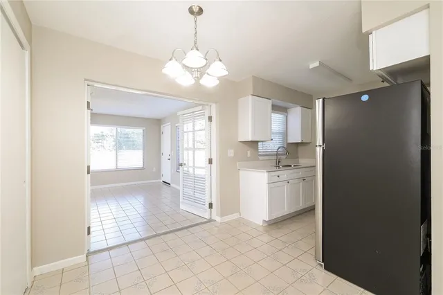 a open kitchen with a sink dishwasher a refrigerator and white cabinets