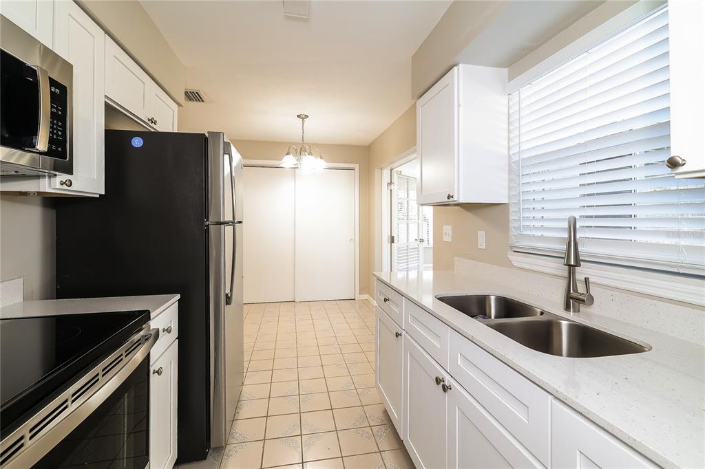 4243 Cynthia Street Orlando, FL 32811 - Photo 7 of 16 a kitchen with stainless steel appliances a sink a stove and a refrigerator