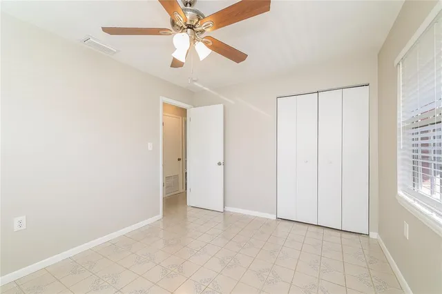 an empty room with fan and windows