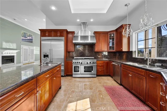 a kitchen with stainless steel appliances granite countertop a sink a stove and a refrigerator