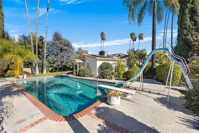a view of a house with backyard water fountain and sitting area