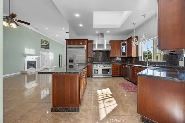 a large kitchen with stainless steel appliances granite countertop a stove and a sink