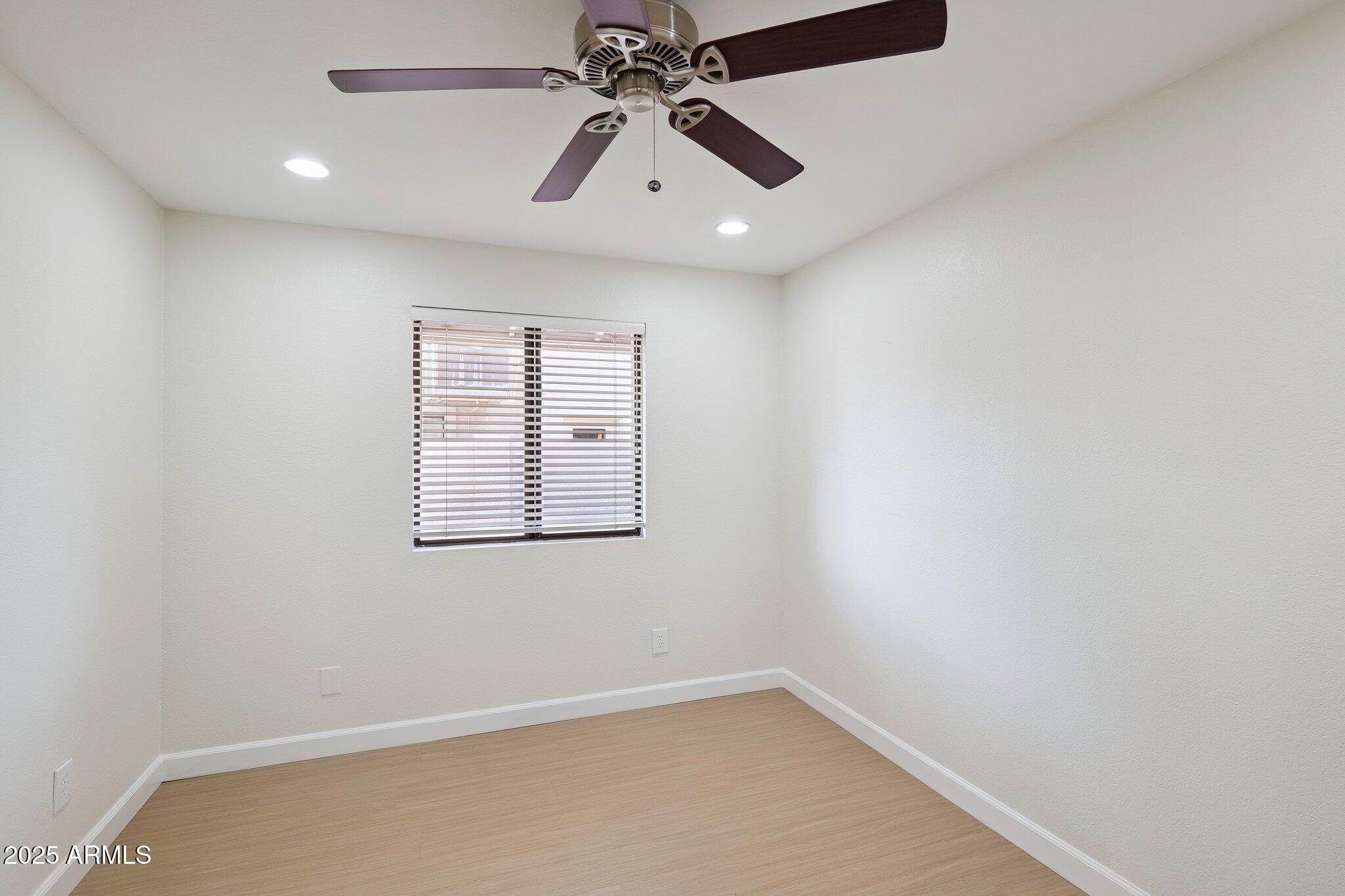 15 East Kathleen Road Phoenix, AZ 85022 - Photo 27 of 40 an empty room with chandelier fan and windows