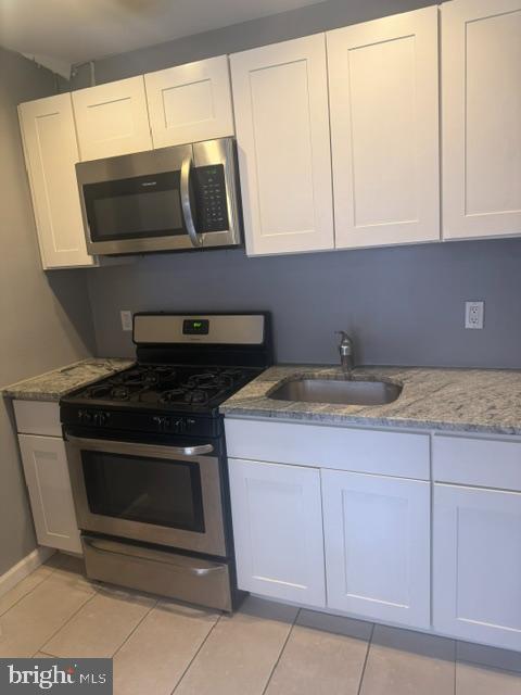 1224 Tasker Street, Unit 1R Philadelphia, PA 19148 - Photo 3 of 9 a kitchen with granite countertop white cabinets and stainless steel appliances