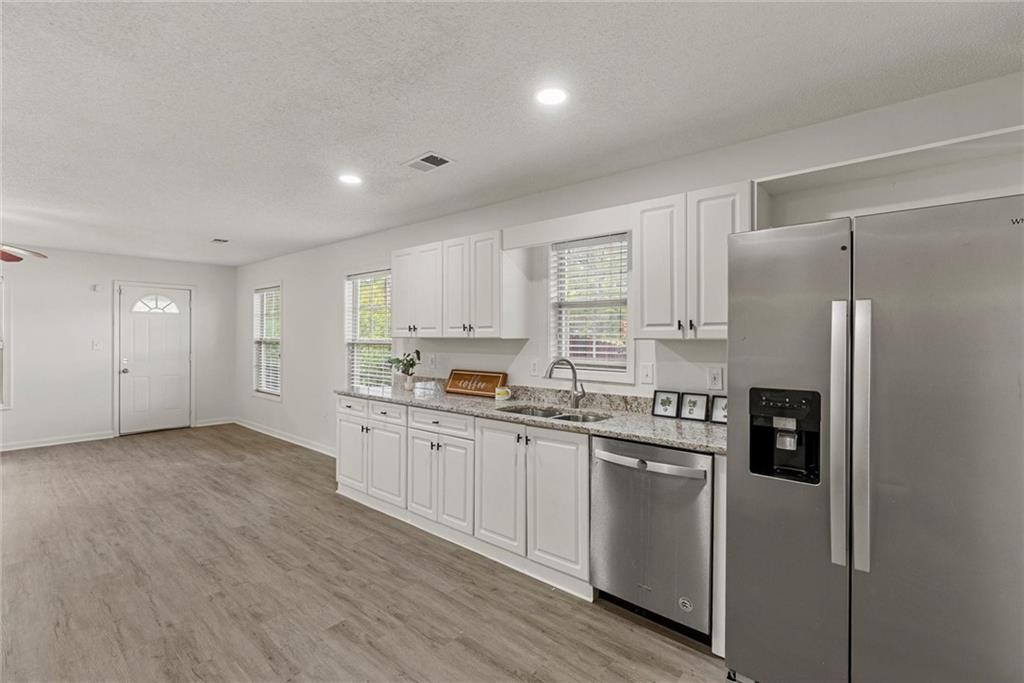 3003 Brass Drive Austell, GA 30106 - Photo 8 of 26 a kitchen with stainless steel appliances granite countertop a refrigerator sink and white cabinets