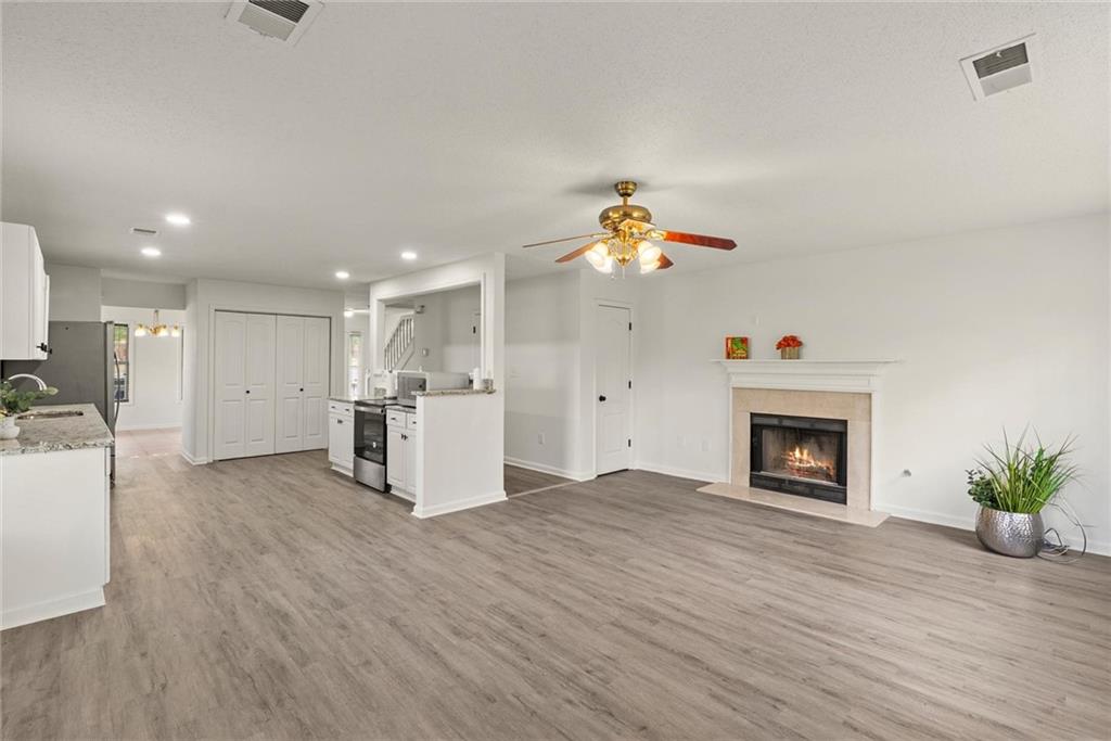 3003 Brass Drive Austell, GA 30106 - Photo 10 of 26 a view of an empty room and kitchen with fireplace wooden floor