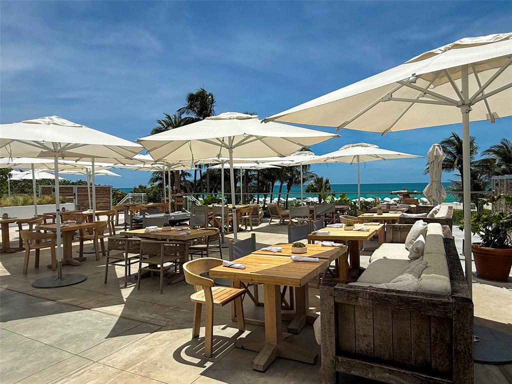 2301 Collins Avenue, Unit 323 Miami Beach, FL 33139 - Photo 29 of 33 a view of a patio with a dining table and chairs under an umbrella