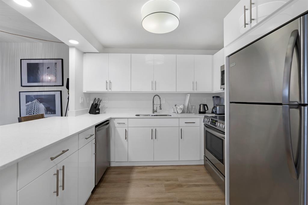 2301 Collins Avenue, Unit 323 Miami Beach, FL 33139 - Photo 4 of 33 a kitchen with a sink stainless steel appliances and cabinets