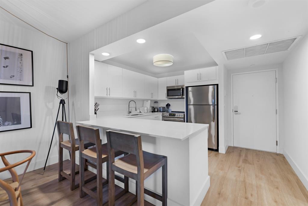 2301 Collins Avenue, Unit 323 Miami Beach, FL 33139 - Photo 5 of 33 a kitchen with stainless steel appliances a sink and a refrigerator